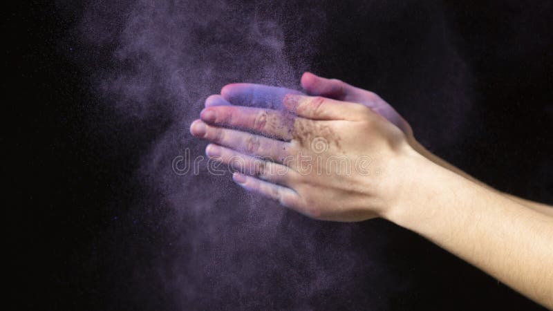 Hands in purple cloud of dry paint. During Holi royalty free stock photography